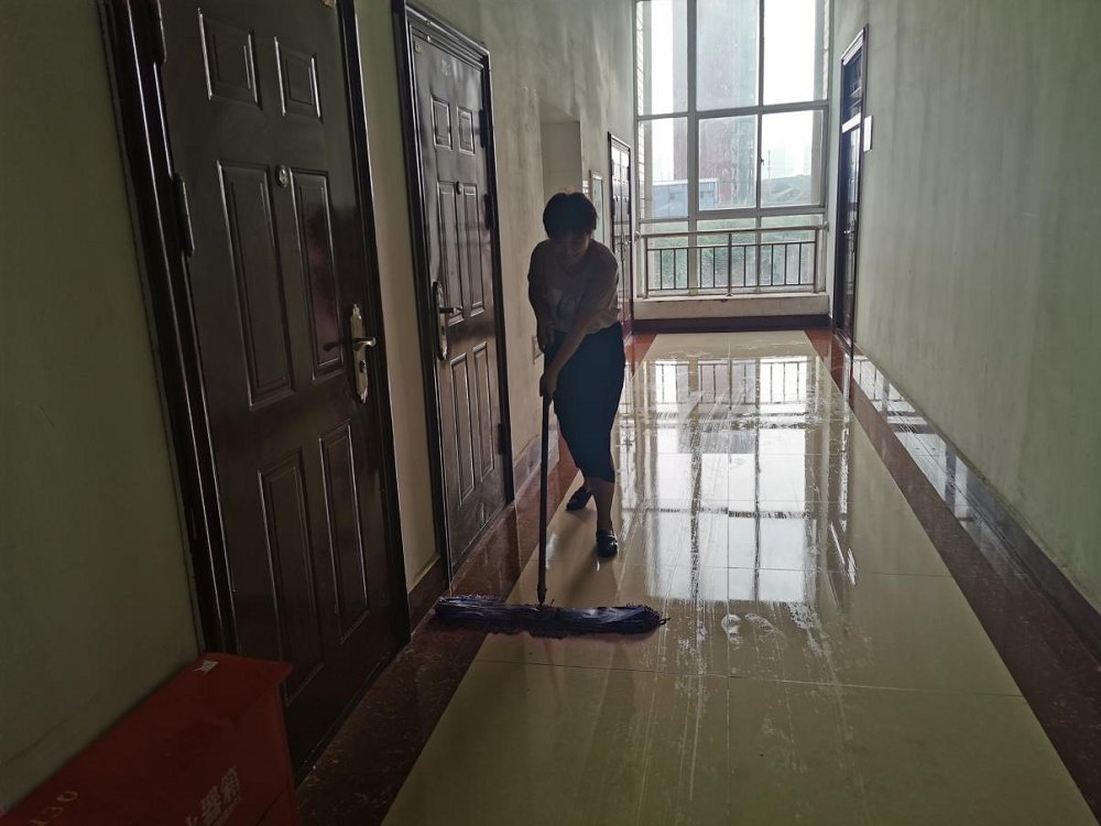 黄月荣老师在打扫走廊.png
